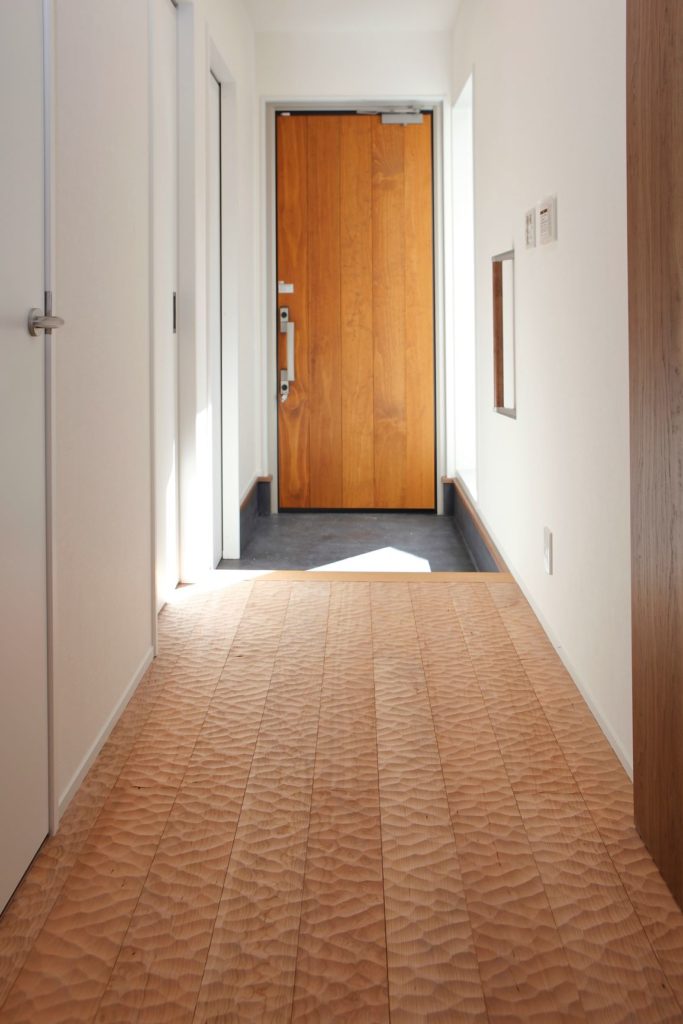 玄関の床材はお施主様のこだわりで無垢の浮造り仕上の床材を使用